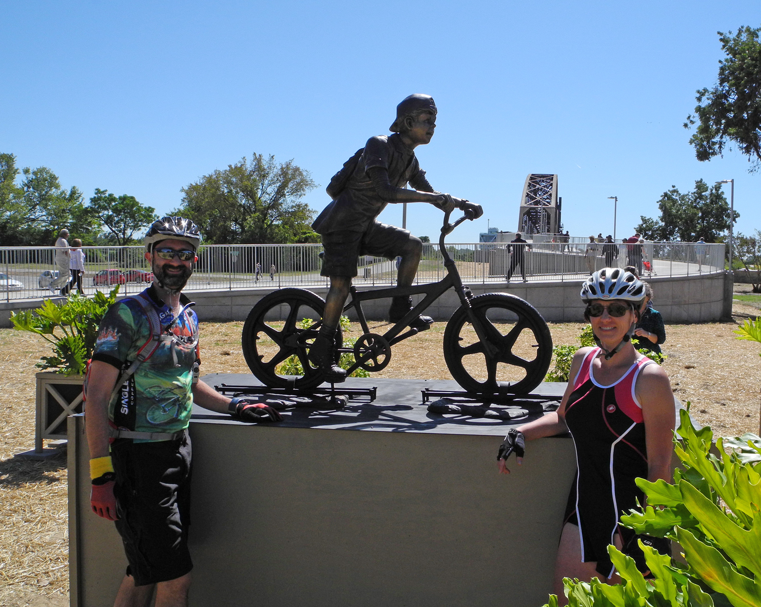 Daron and Lisa pose at the statue of the young man on a bike at the North Little Rock side of the bridge.