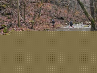 Two hikers carefully cross Bear Creek during a recent hike in the Ozark National Forest.
