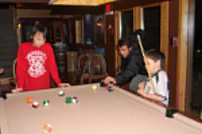 Dr. Wayne schooling the boys in the finer points of pool.