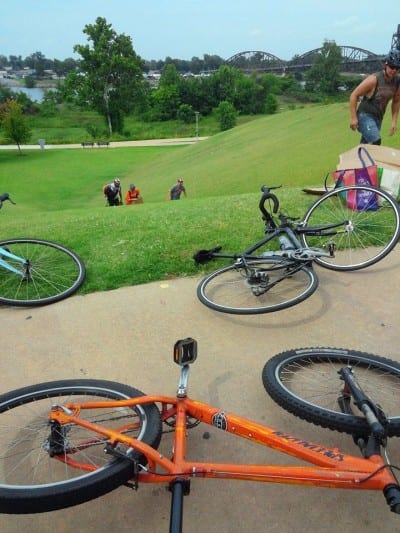 The bikes are replaced by cardboard for a quick trip down the grassy hill. (photo by Brian Pearce)