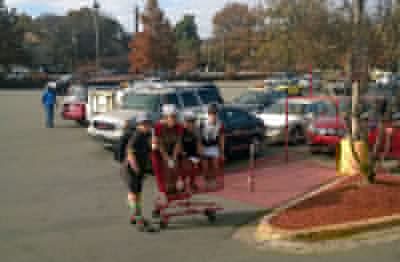 Get all your teammates inside shopping carts (except for whoever is pushing the carts and whoever is taking the photo) and roll the carts from end of the super market to the other side of the parking lot.
