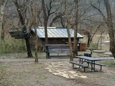 Picnic tables from the pavilion (extreme left behind cars) were hung in trees by the river at Tyler Bend.