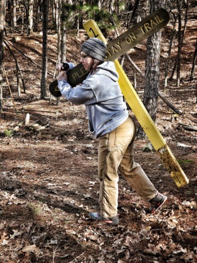 Lisa, one of the original trail builders, hauling out an older sign.