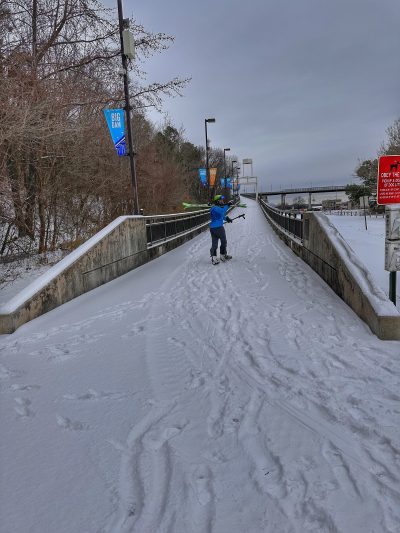 Skier walking up the ramp of the Big Dam Bridge.