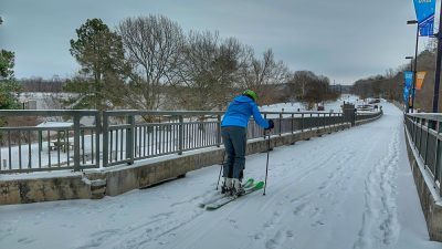 Skier taking a ski run down the ramp of the Big Dam Bridge.