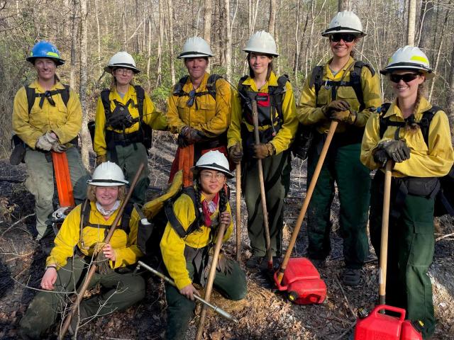 The Southern Region Women in Wildfire crew pose for a photo after a long day of prescribed burning in the Pisgah National Forest in North Carolina. They participated in just over 25,000 acres of prescribed burning in the Southern Region this season. The crew traveled to five different states and spent 22 days conducting prescribed burns. USDA Forest Service photo by Elizabeth Bunzendahl.