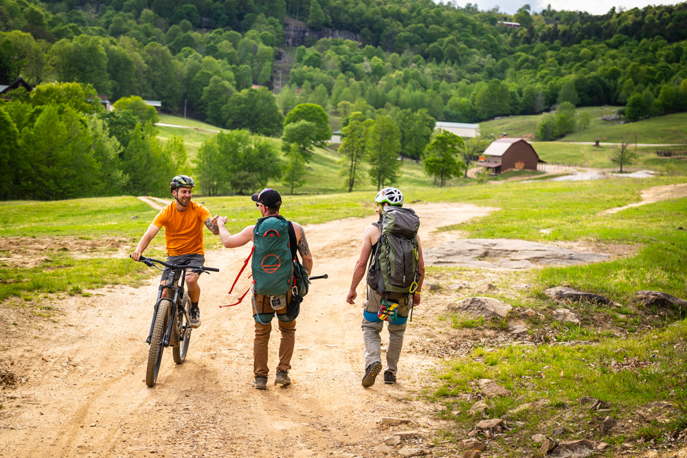A mountain biker and a couple of rock climbers meet on the trail.