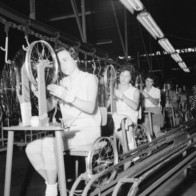 Women test bicycle rims for "trueness" on June 19, 1963, during a visit by Arkansas Gazette columnist Ernie Deane to the assembly line of the AMF Cycle Division factory on 65th Street in Little Rock. (photo courtesy of the Arkansas History Commission.