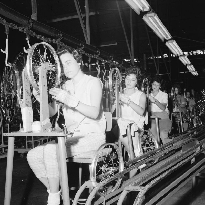 Women test bicycle rims for "trueness" on June 19, 1963, during a visit by Arkansas Gazette columnist Ernie Deane to the assembly line of the AMF Cycle Division factory on 65th Street in Little Rock. (photo courtesy of the Arkansas History Commission.