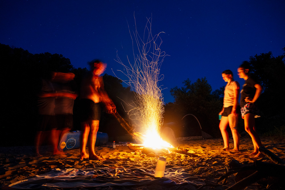 A group standing around a fire on a gravel bar at the Buffalo National River.
