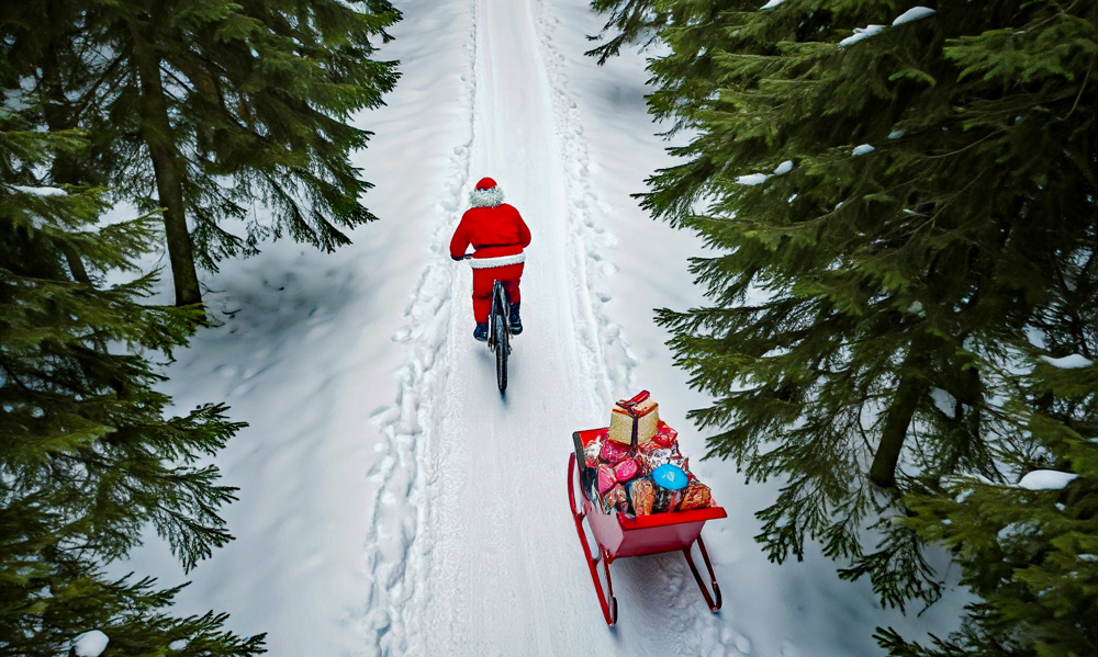 Santa pulling the sleigh on his mountain bike.