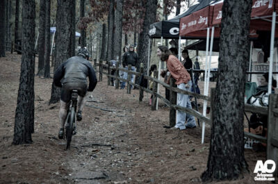 Spectator yelling at mountain bike competitor during a rainy race.