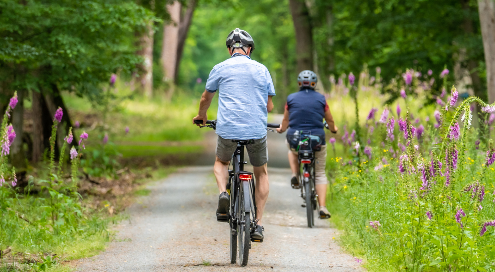 Couple riding bicycles on a gravel road.