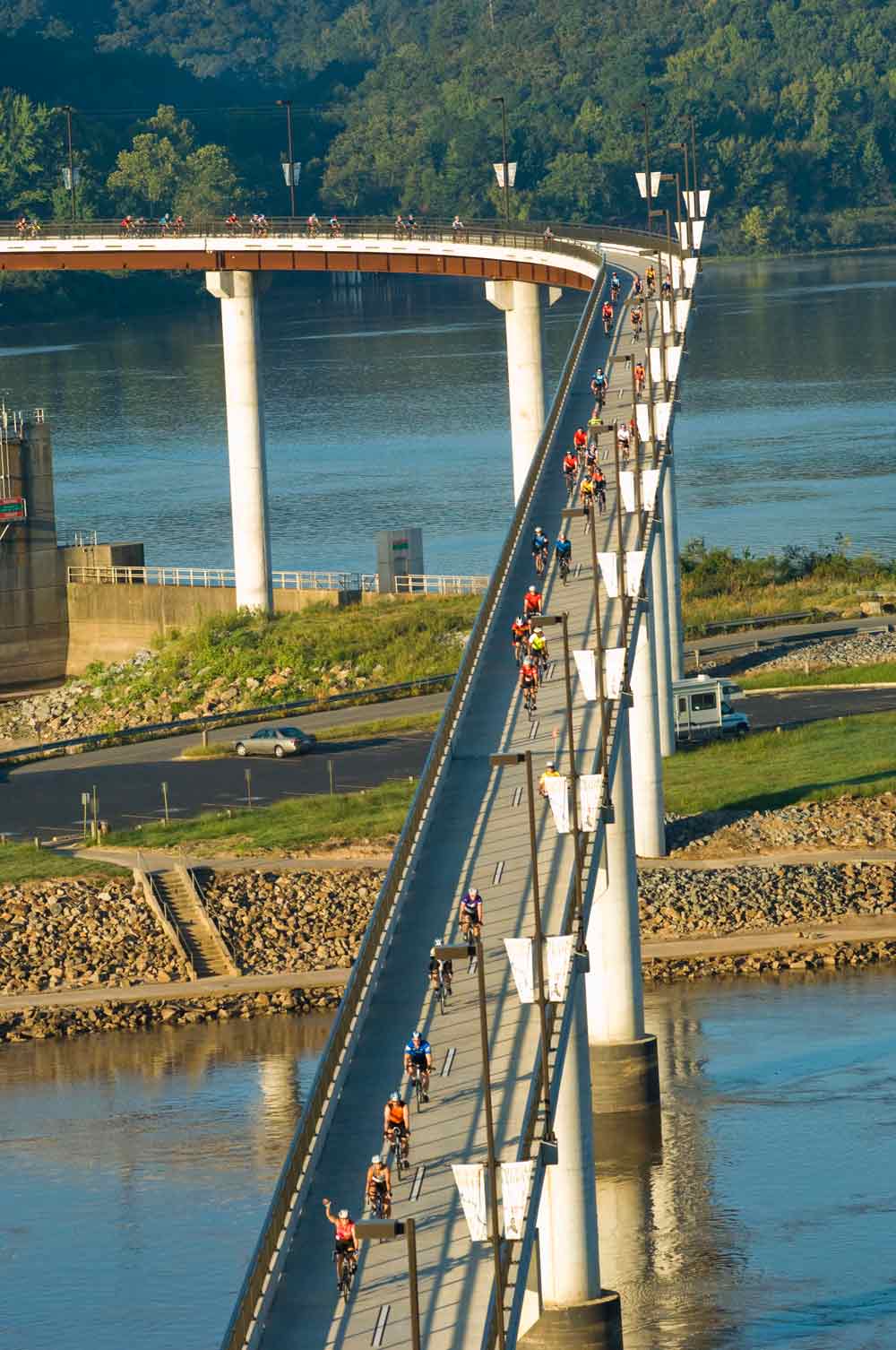 Cyclists crossing the Arkansas River on the Big Dam Bridge.