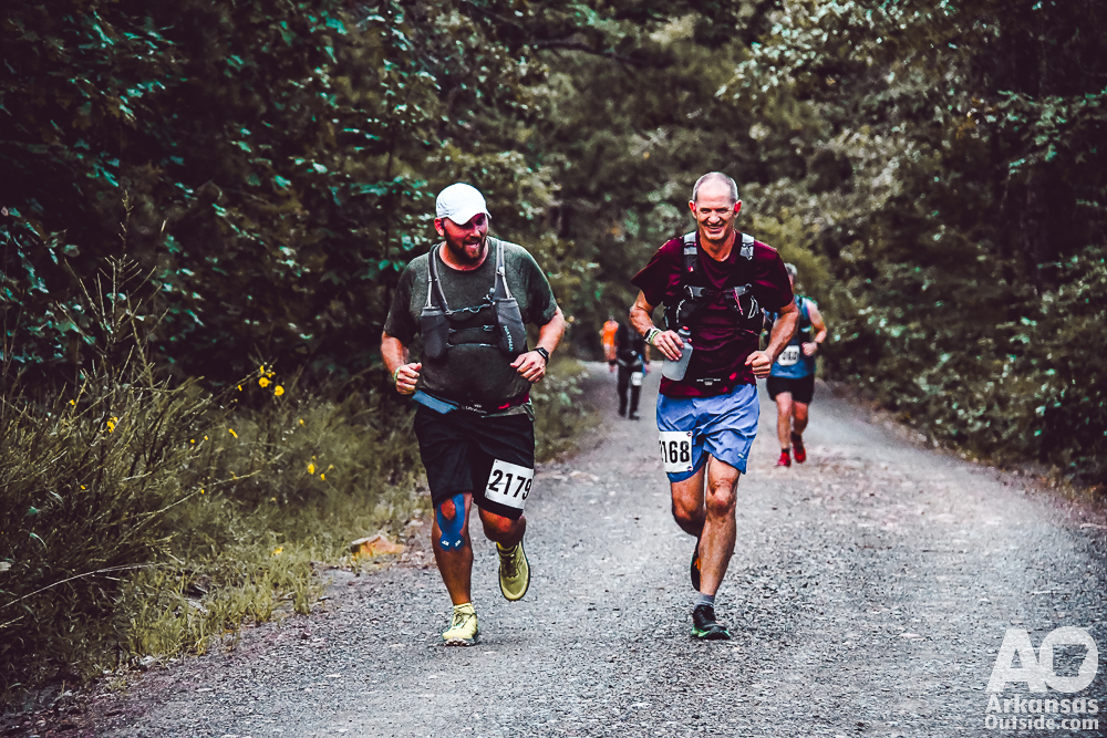 Two runners enjoying a run up a gravel road.