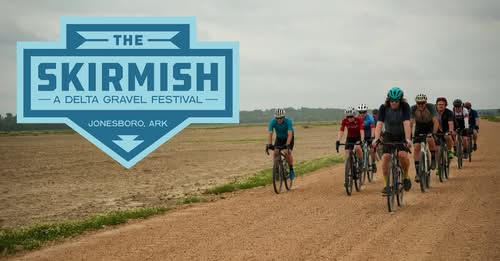A group of cyclists riding gravel roads though farmlands.