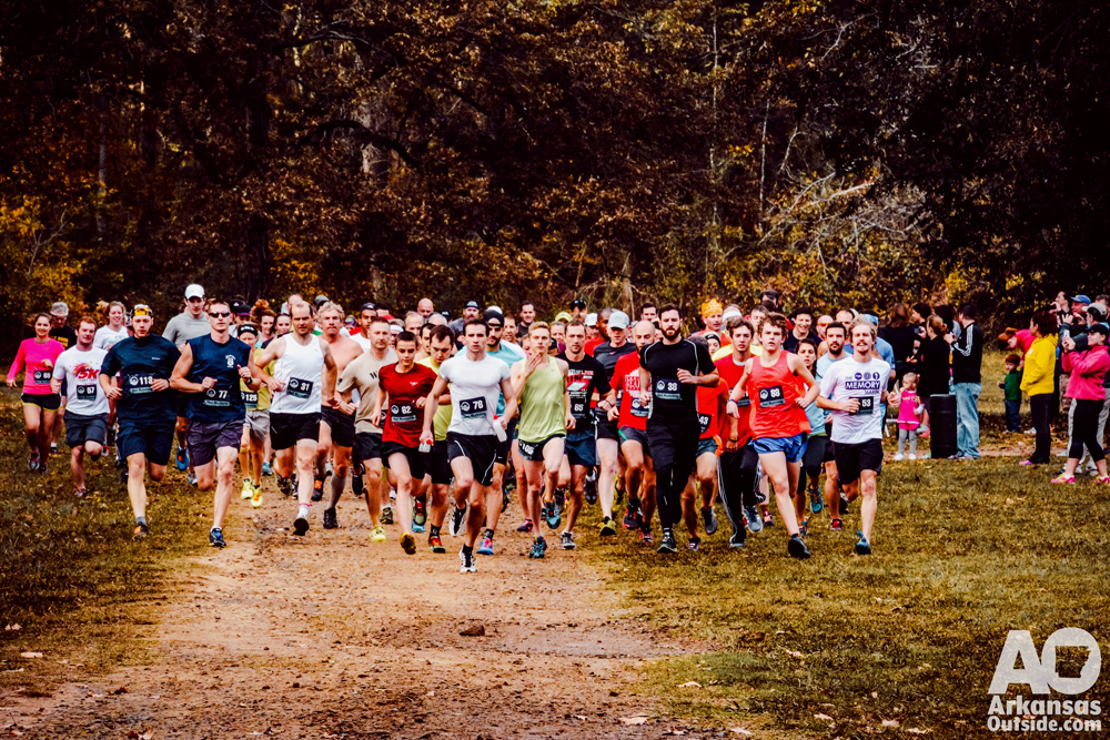 A group of runners at the race start in a field.
