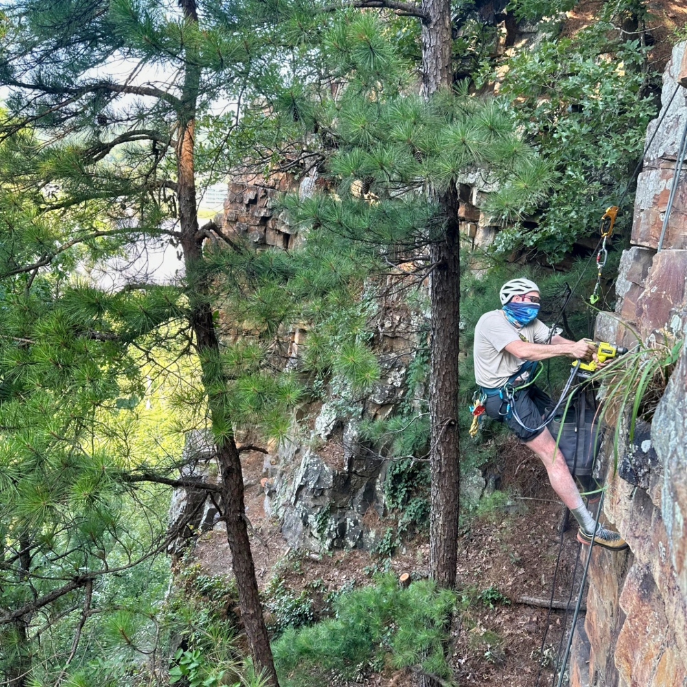 A volunteer from the Arkansas Climbers Coalition creating a safe climbing route at Crystal Bluffs.