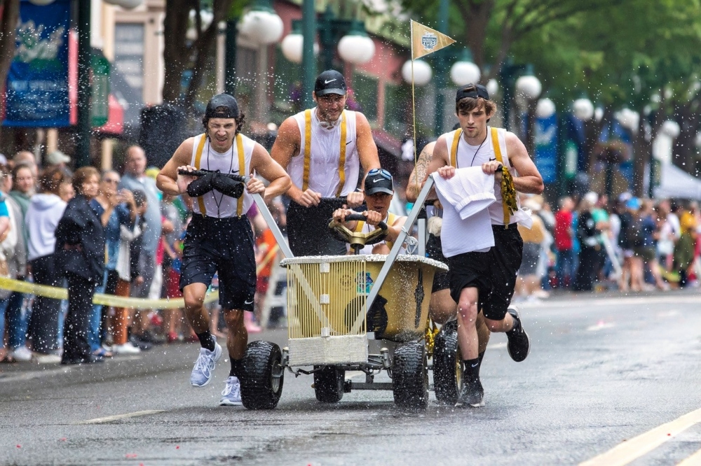 Costumed team pushing a water filled bathtub during the Running of the Tubs race in downtown Hot Springs