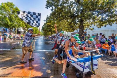 Crowds spraying racers with water along Bathhouse Row at the Running of the Tubs event