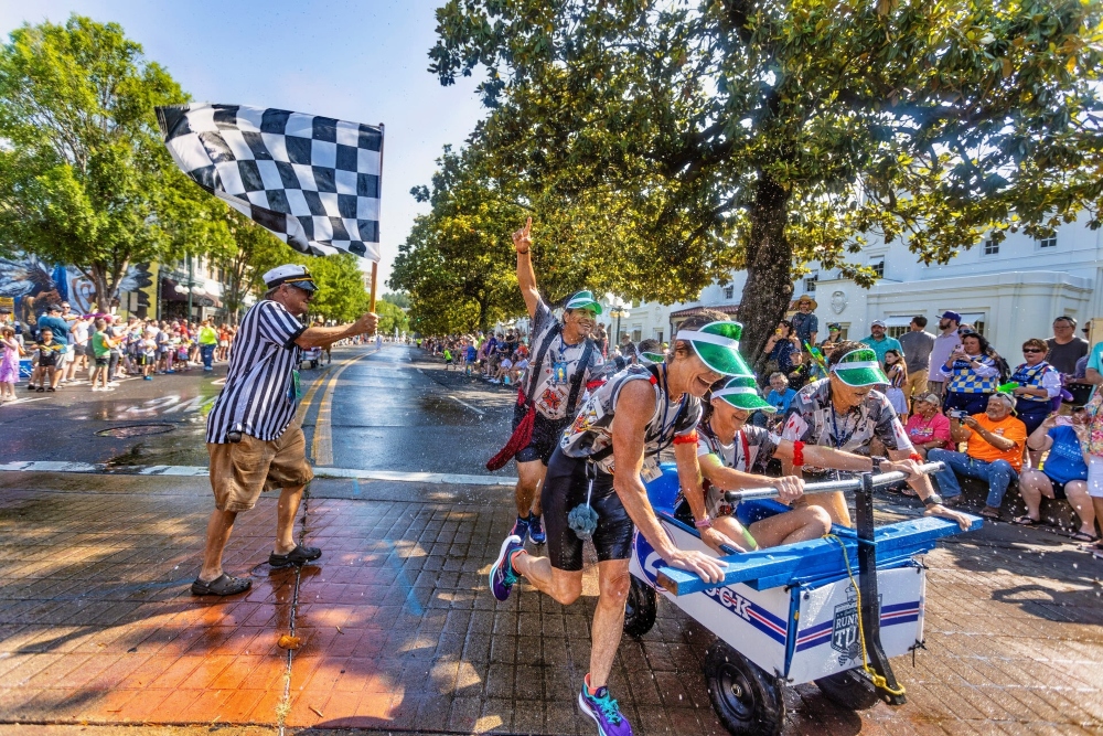 Crowds spraying racers with water along Bathhouse Row at the Running of the Tubs event