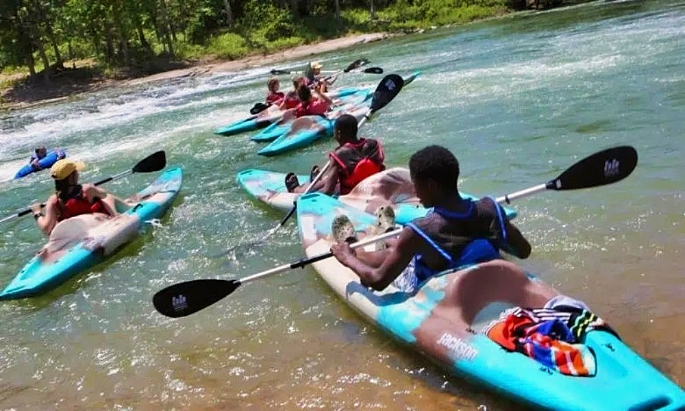 A group heading out on the Illinois River in kayaks.